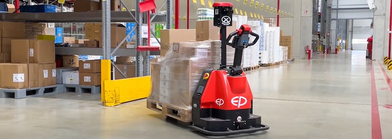 Automatische palletwagen rijdend in een magazijn